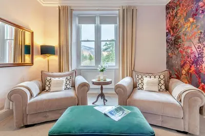 a living room with two chairs and a table at Cameron Fell Apartment Keswick at The Lairbeck in Keswick