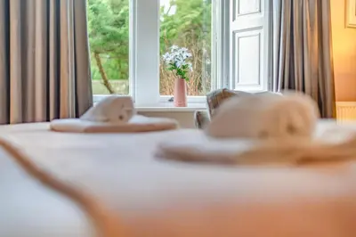a room with a window and a table with towels at Bethby Beck Apartment Keswick at The Lairbeck in Keswick