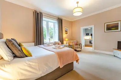 a bedroom with a bed and a living room at Bethby Beck Apartment Keswick at The Lairbeck in Keswick