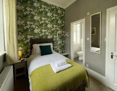a bedroom with a bed with a green blanket at The Capsule Room at The Lairbeck in Keswick in Keswick