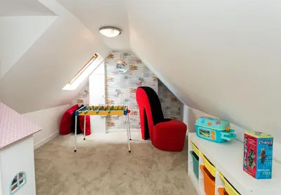 a attic room with a table and red chairs at 118 High Street in Kirkcudbright