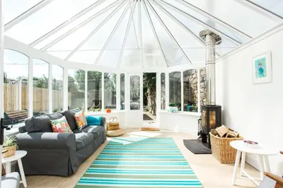 a living room with a couch and a conservatory at 118 High Street in Kirkcudbright