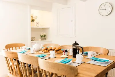 a dining room table with a tea kettle and bread on it at 118 High Street in Kirkcudbright
