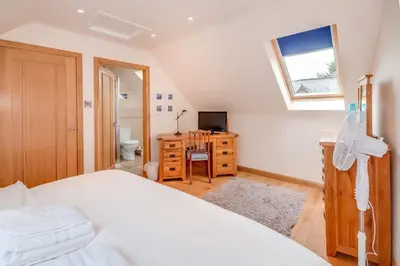 a bedroom with a bed and a desk and a window at Kinnen Cottage in Creetown