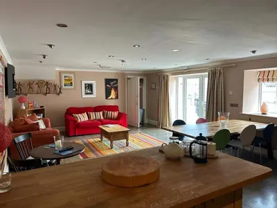 a living room with a red couch and a table at The Wickerman Granary in Kirkcudbright