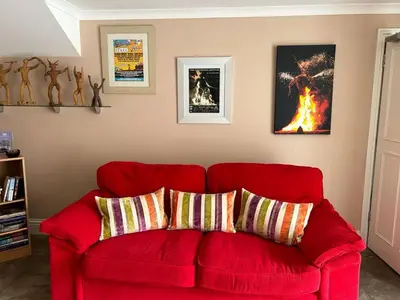 a red couch with two pillows in a living room at The Wickerman Granary in Kirkcudbright