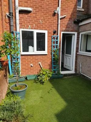 a house with a yard with plants and a door at Family Home Near City Centre - New KING bed! in Carlisle