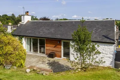 a small white house with a tree in front of it at Skerrow in New Galloway