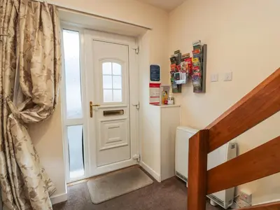 a hallway with a white door and a window at Barley Cottage in Newton Stewart