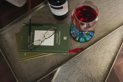 a table with a book and glasses and a bottle of wine at Bellfoot Rural Retreat and Hot Tub in Grasmere