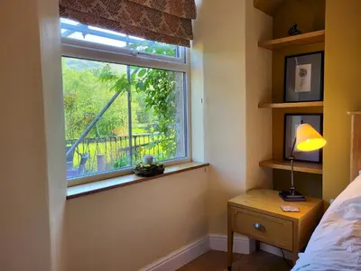 a bedroom with a window and a bed and a lamp at Lingmoor Cottage in Chapel Stile