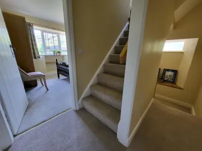 a hallway with a staircase in a house at Lingmoor Cottage in Chapel Stile