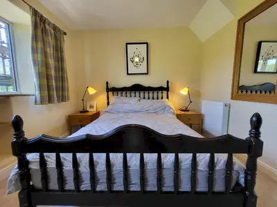 a bedroom with a black bed with two night stands at Lingmoor Cottage in Chapel Stile