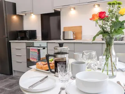 a kitchen with a table with plates and flowers on it at Lands Brow Lodge in Red Dial