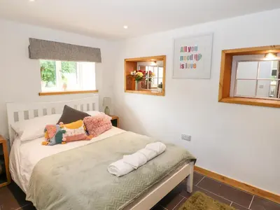 a bedroom with a bed and two windows at Lands Brow Lodge in Red Dial