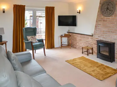 a living room with a couch and a fireplace at Rivendell in Burgh by Sands