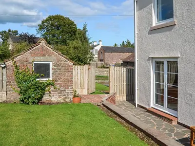 a backyard with a fence and a house at Rivendell in Burgh by Sands