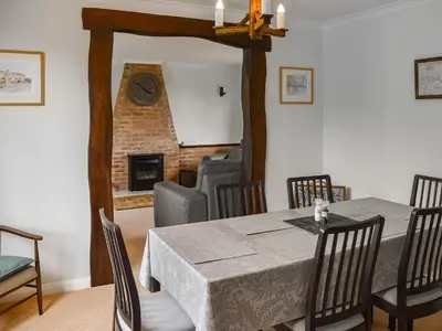 a dining room with a table and a fireplace at Rivendell in Burgh by Sands