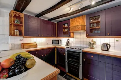 a kitchen with purple cabinets and a bowl of fruit on the counter at 2 Bed in Elterwater oc-gl004 in Chapel Stile