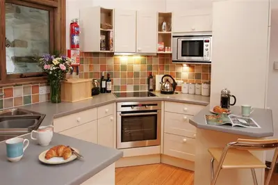 a kitchen with white cabinets and a plate of food on a counter at 2 Bed in Grasmere oc-gl007 in Grasmere