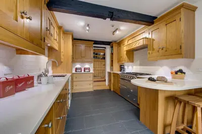 a large kitchen with wooden cabinets and white counter tops at 5 Bed in Grasmere oc-gl008 in Grasmere