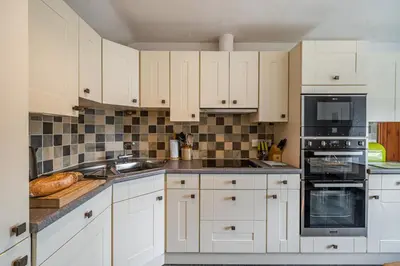a kitchen with white cabinets and black appliances at 3 Bed in Elterwater oc-gl011 in Chapel Stile