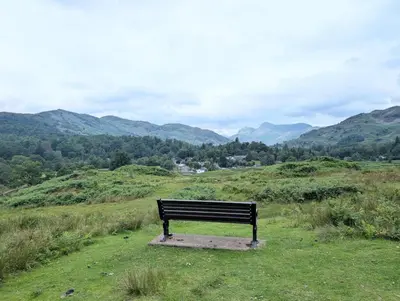 a bench sitting on top of a grassy hill at 2 Bed in Elterwater oc-gl053 in Chapel Stile