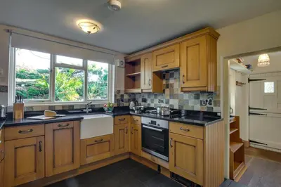 a kitchen with wooden cabinets and black counter tops at 3 Bed in Little Langdale oc-gl102 in Little Langdale