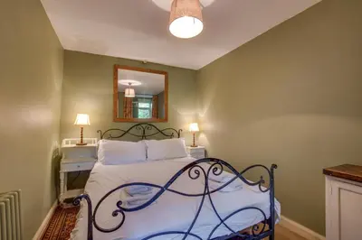 a bedroom with a bed and a mirror on the wall at 3 Bed in Little Langdale oc-gl102 in Little Langdale