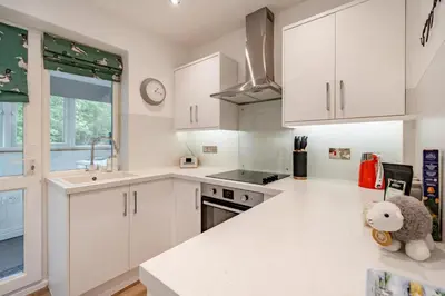 a kitchen with white cabinets and a teddy bear on the counter at 2 Bed in Chapel Stile oc-gl103 in Chapel Stile