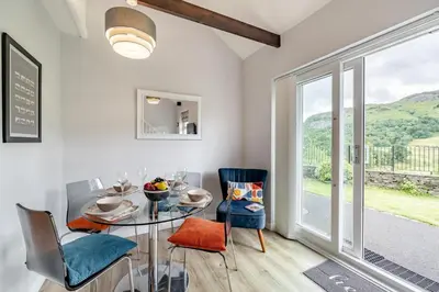 a dining room with a table and chairs and a window at 2 Bed in Chapel Stile oc-gl103 in Chapel Stile