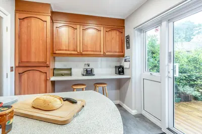 a kitchen with a table with a loaf of bread on a cutting board at 2 Bed in Grasmere oc-ld175 in Grasmere