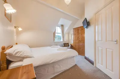 a bedroom with a bed and a table and a window at 6 Bed in Keswick oc-ld177 in Keswick