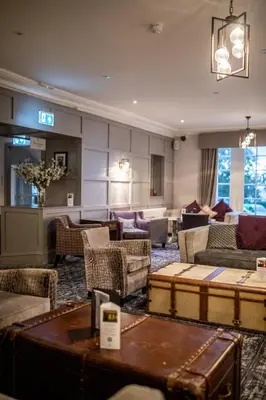 a living room with couches and chairs and a table at Gretna Hall Hotel in Gretna Green