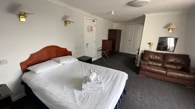 a hotel room with a bed and a couch at The Bruce Hotel in Newton Stewart
