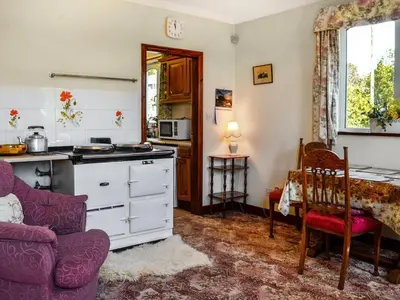 a kitchen with a couch and a table in a room at Rose Rigg Cottage in Kirklinton