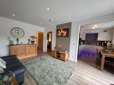 a living room with a couch and a dining room at Cairnyard Lodges - Woodrow in Beeswing