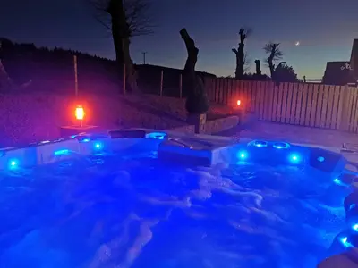a hot tub with blue lights in a yard at night at Cairnyard Lodges - Woodrow in Beeswing