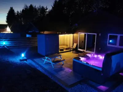 a backyard with a hot tub at night at Cairnyard Lodges - Woodrow in Beeswing