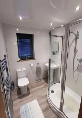 a bathroom with a shower and a toilet and a sink at Cairnyard Lodges - Woodside in Beeswing