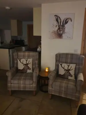 two chairs with deer heads on them in a living room at Strathken Cottage in Castle Douglas