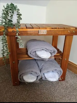 a pile of towels on a shelf with a plant at Strathken Cottage in Castle Douglas