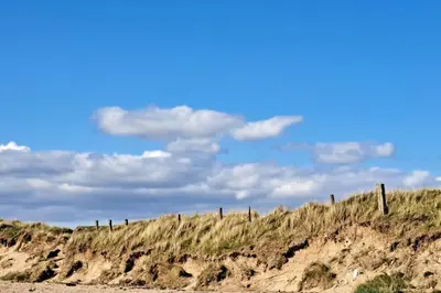a fence on the side of a sandy beach at Apartment - Sleeps 4 - Pet friendly - Parking in Troon
