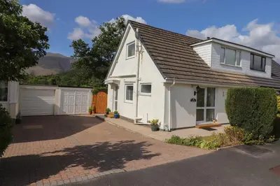 a white house with a garage at Oaklea in Keswick