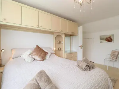 a bedroom with a large white bed with pillows on it at Oaklea in Keswick