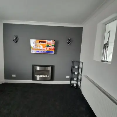a living room with a fireplace and a tv at J & S Apartments in Ayr