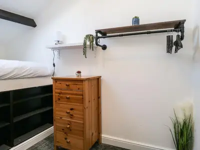 a bedroom with a bed and a wooden dresser at 8A Corkickle in Whitehaven