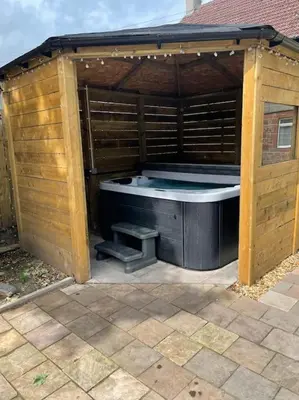 a wooden structure with a hot tub in a backyard at Lovely 2 bed apartment with hot tub log burner and off street parking in Dumfries
