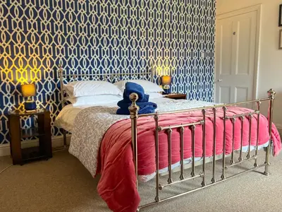 a bedroom with a bed and a blue and white wall at Little Parrock, Grasmere nestled at the foot of Helm Crag with walks from the door in Grasmere