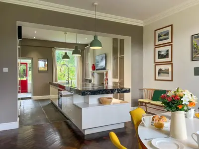 a kitchen and living room with a counter and a table at Little Parrock, Grasmere nestled at the foot of Helm Crag with walks from the door in Grasmere